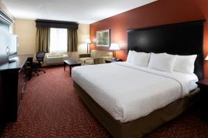 CambridgeGrandStay Hotel & Suites的酒店客房设有一张大床和一张书桌。