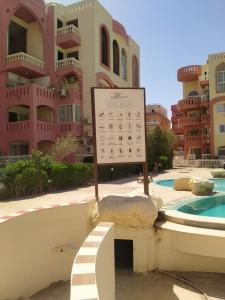 沙姆沙伊赫2 Bedroom Apartment with pool view的一座带游泳池的建筑前的标志