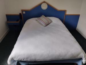 萨尔特河畔萨布雷initial by balladins Sable sur Sarthe的一张带蓝色床头板和枕头的白色床