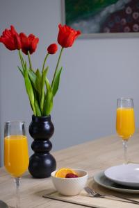 里耶卡Deluxe Apartments "Nona Fa"的一张桌子,上面放着两杯橙汁和红花