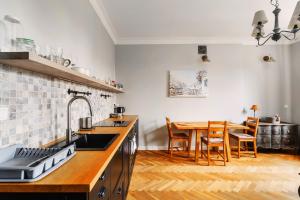 华沙Designer flat in the heart of Old Town的厨房配有水槽和桌椅