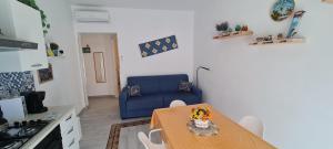 特拉帕尼La Siciliana Trapani Apartment的客厅配有桌子和蓝色沙发