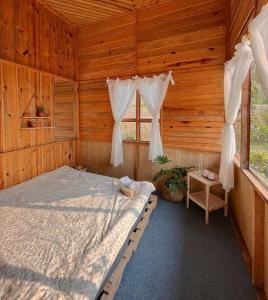 Ấp Phước ThánhPhòng lẻ - Góc sân và Khoảng trời Dalat Homestay的小木屋内一间卧室,配有一张床