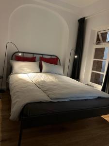 不莱梅Apartment im Geteviertel - citynah的一张带红色和白色枕头的床和窗户