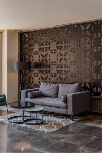 梅里达Hotel Kavia Premium - Paseo Montejo的客厅配有沙发和桌子