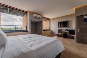梅里达Hotel Kavia Premium - Paseo Montejo的酒店客房设有一张大床和一张书桌。