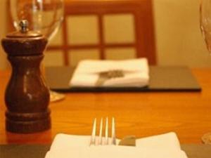 雷丁纽乌酒店的桌子上一张桌子,上面有叉子和餐巾