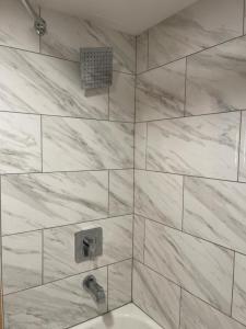 鸽子谷熊山酒店的浴室设有白色大理石瓷砖和淋浴。