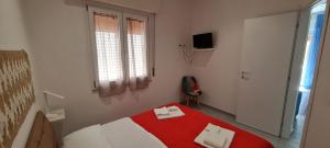 特拉帕尼La Siciliana Trapani Apartment的卧室设有红色和白色的床和窗户。