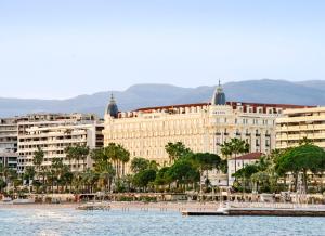 戛纳Carlton Cannes, a Regent Hotel的靠近水体的大建筑