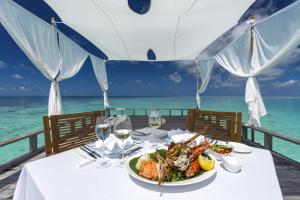 马累马尔代夫环球度假村的一张桌子,上面有一盘食物和海洋