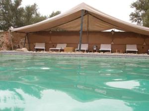 HeddadTente du Borj Zarraba的一个带帐篷和椅子的大型游泳池