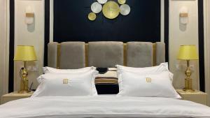 杜阿拉Suna' a Home Bonapriso的卧室配有带白色枕头的大床