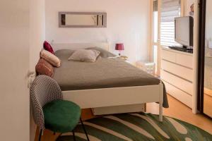 拉罗谢尔CHEZ BARA的一间卧室配有一张带绿椅的床和电视
