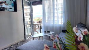 萨罗尼扎VISTA MARE beachfront apartment.的带沙发和桌子的客厅以及阳台。