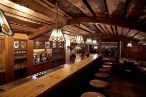 雷特温克尔Hotel Almrausch的一个带木柜台和凳子的酒吧