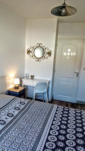雷岛圣玛丽Les Bois Flottés en Ré的一间卧室配有一张床、一张桌子和一面镜子