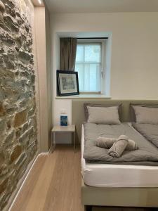 Tenna API Tenna Apartments Glicine 1的石墙房间内的一张床位