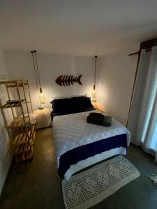 马劳Estudio Lirios seu cantinho ecológico na natureza的一间卧室配有一张带鱼床头板和灯的床。