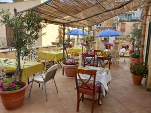 阿格里真托B&B Batarà - "La Terrazza del Centro"的一间带桌椅和蓝伞的餐厅