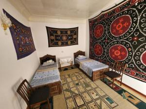 布哈拉Zafar Family Guesthouse的一间设有两张床的房间和一张地毯