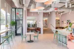 纳什维尔TownePlace Suites Nashville Downtown/Capitol District的一间设有粉红色墙壁、绿色椅子和柜台的房间