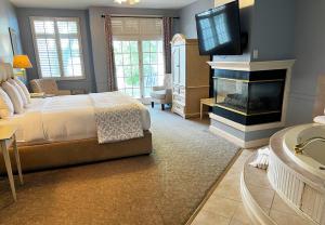 日内瓦湖The Sand Hill Inn的一间卧室配有一张床、一个壁炉和一台电视。