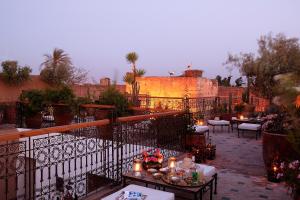 马拉喀什阿拉丁摩洛哥传统庭院住宅的阳台的天井配有桌子和蜡烛