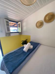 欧鲁普雷图É Hostel的一间卧室配有一张黄色和蓝色毯子的床
