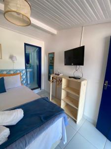 欧鲁普雷图É Hostel的一间卧室配有一张床和一台平面电视