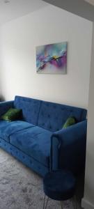 牛顿勒威洛斯Rydal house with office space newly refurbished的客厅里一张蓝色的沙发,上面有绘画作品