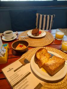 若昂佩索阿Kastel Jampa Hotel的一张桌子,上面放着两盘食物和烤面包