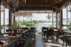河内河内清晨酒店的一间带桌椅并享有河景的餐厅