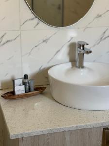 ChomaLEGENDS EXECUTIVE LODGE的浴室的柜台设有水槽和镜子