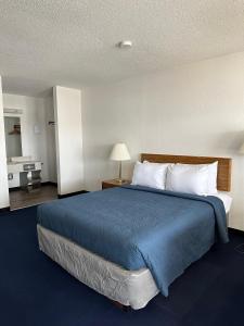 圣伊尼亚斯Bayside Inn的一间卧室配有一张带蓝色毯子的大床