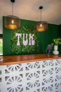 威廉斯塔德TUK Tropical Boutique Resort Jan Thiel的餐厅绿色墙上的图西语标志