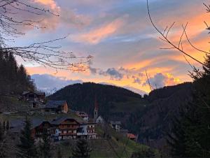 圣洛伦佐-迪塞巴托Thalerhof的山丘上的村庄,背景是日落