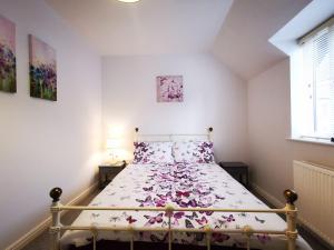 康威Rose Cottage的一间卧室,床上有粉红色的鲜花