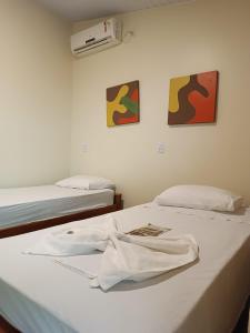 托坎廷斯州蓬蒂阿尔塔Pousada Águas do Jalapão的一间设有两张床和床上衬衫的房间