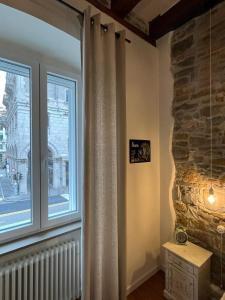 的里雅斯特Santorio 5 Apartment的客房设有带石墙的大窗户。