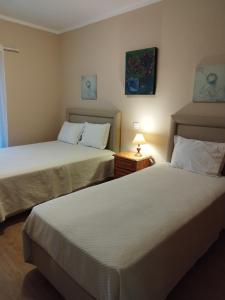 阿尔布费拉阳光酒店的一间卧室设有两张床和一张桌子上的台灯。