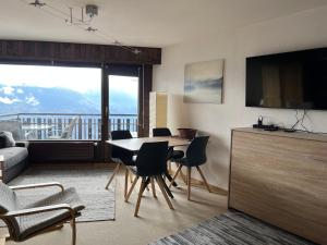 莱斯克伦斯Cosy Studio for 5 near ski lift, Les Gentianes的客厅配有桌椅和电视。