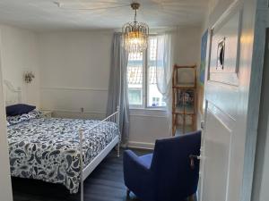 艾勒斯克宾Badehotel Harmonien的一间卧室设有一张床、一个窗口和两把椅子