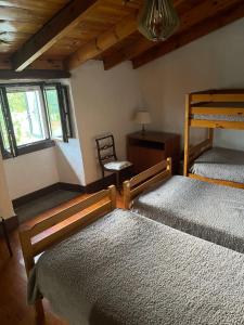 卢戈Albergue Rectoral de Romean的一间卧室配有两张双层床和椅子