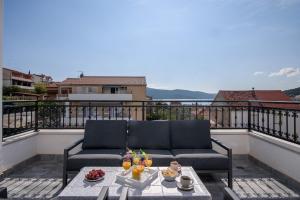 希杰弗朗吉卡Villa Barbara & Zoran with heated swimming pool的阳台上的沙发,餐桌上的食物