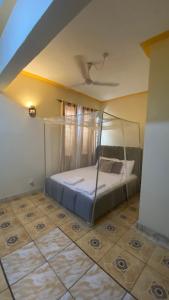 蒙巴萨Al Maaroof Appartment的一间卧室配有一张带天蓬的床