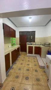 蒙巴萨Al Maaroof Appartment的厨房配有棕色橱柜,铺有瓷砖地板。