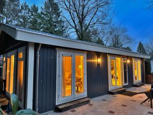 伊皮Stayatsas Tiny House Julia in de bossen op de Veluwe!的一个小房子,设有窗户和庭院