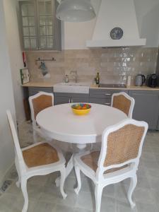 奥良Casa Rosa的厨房里配有白色的桌椅