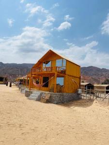 NuweibaFull Moon Camp Sinai的沙漠中间的一座木结构建筑
